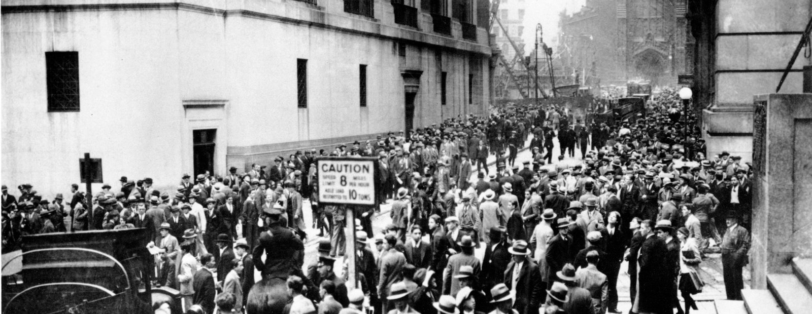 A dense crowd of men in hats filling the street outside the New York Stock Exchange in October 1929.