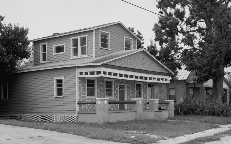 A modest Tampa bungalow with a front porch, seen from the street.
